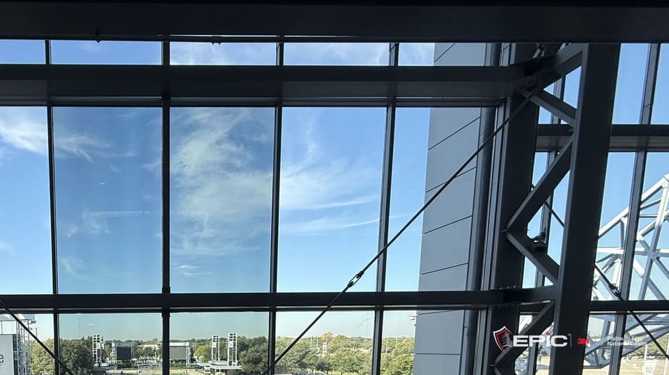 Film samples hung on the west end zone glass wall at AT&T Stadium, seen from inside