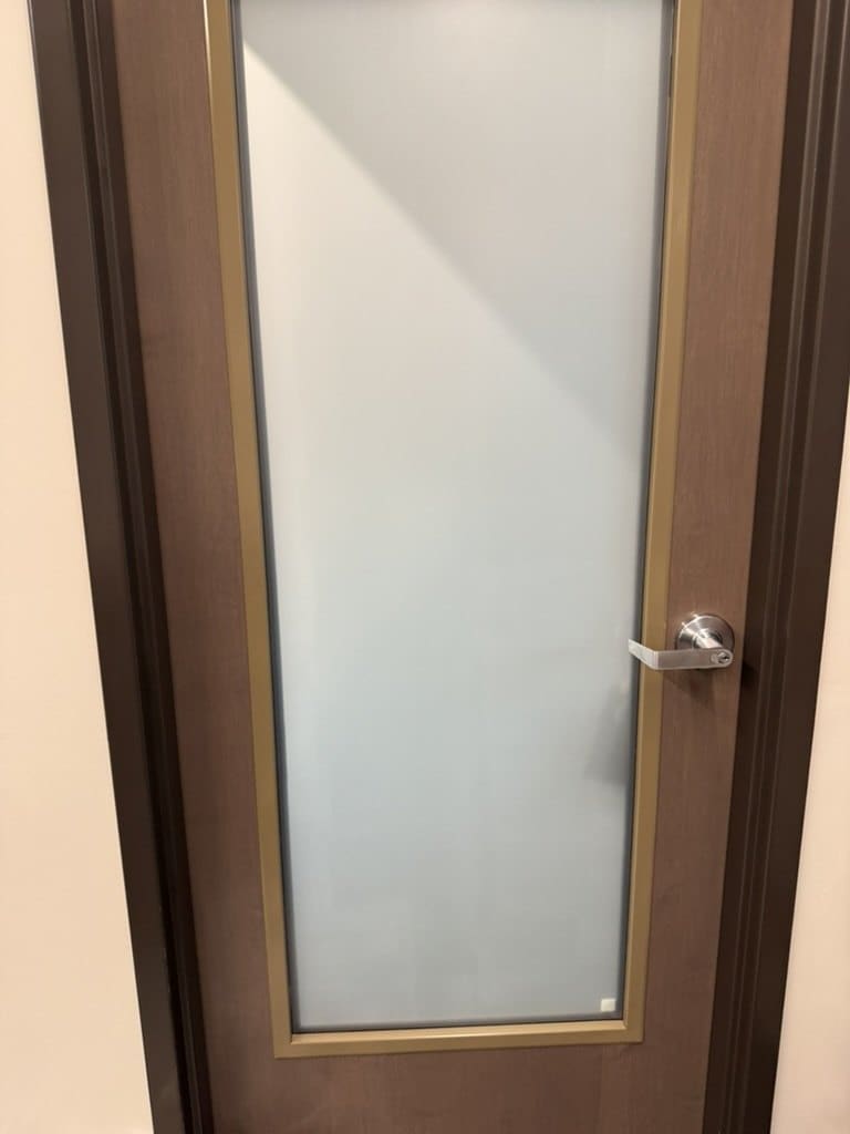 Office door with a full-length glass lite covered in matte privacy film