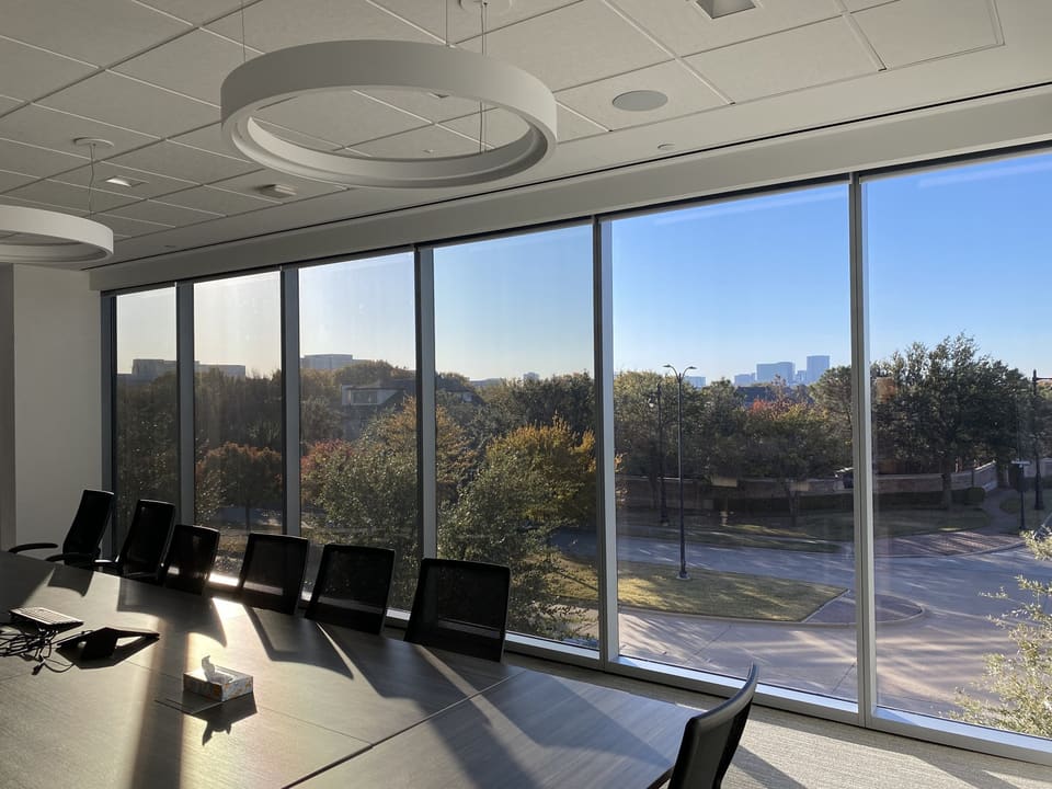 Conference room with floor-to-ceiling glass after 3M solar film — the view stays clear, the heat does not