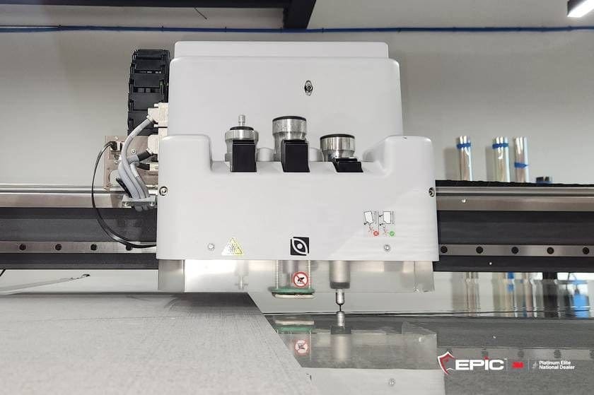 The Epic Precision cutting head over the bed with 3M Ultra S800 on the table, rolls of film racked behind