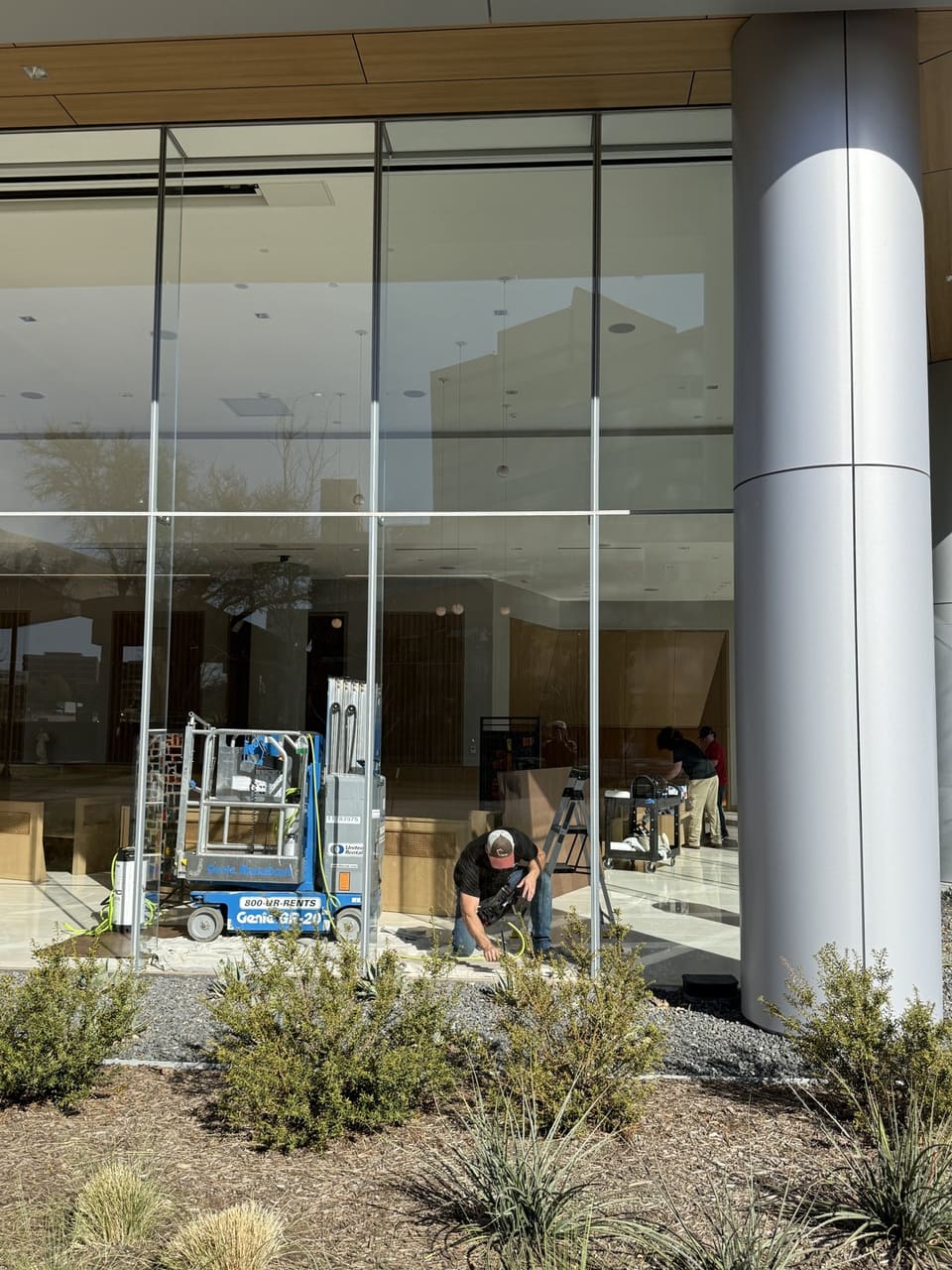 Two Epic Certified Installation Specialists at the exterior glass, one on a scissor lift
