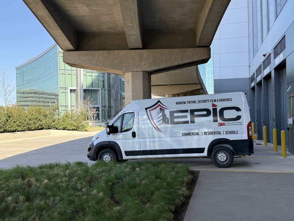 Epic van parked beside the building under an elevated roadway in Irving