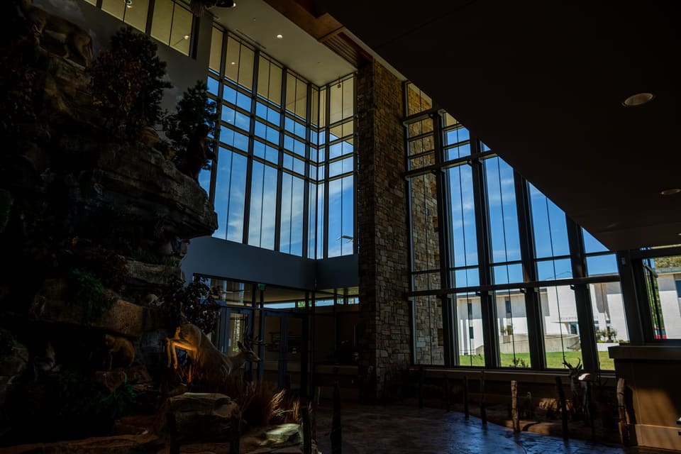 Completed lobby glass at the Oklahoma Department of Wildlife Conservation, with the stone wall and trees beyond