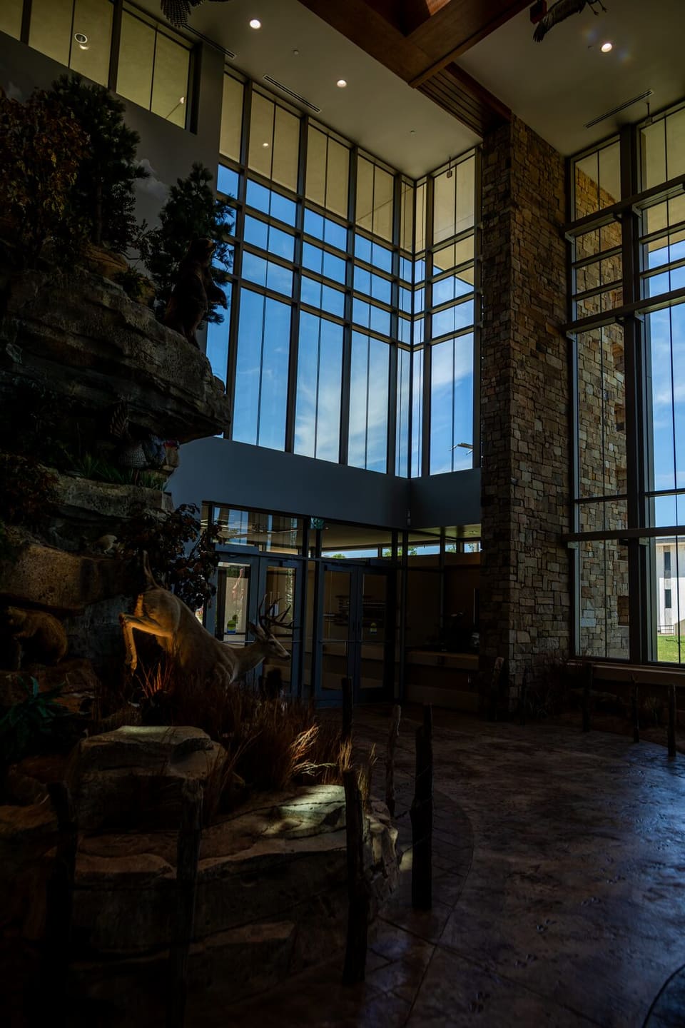 Completed lobby glass at the Oklahoma Department of Wildlife Conservation, with the stone wall and trees beyond