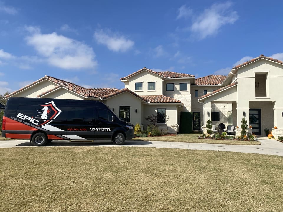 Epic van at the curb of a Mediterranean-style North Texas home