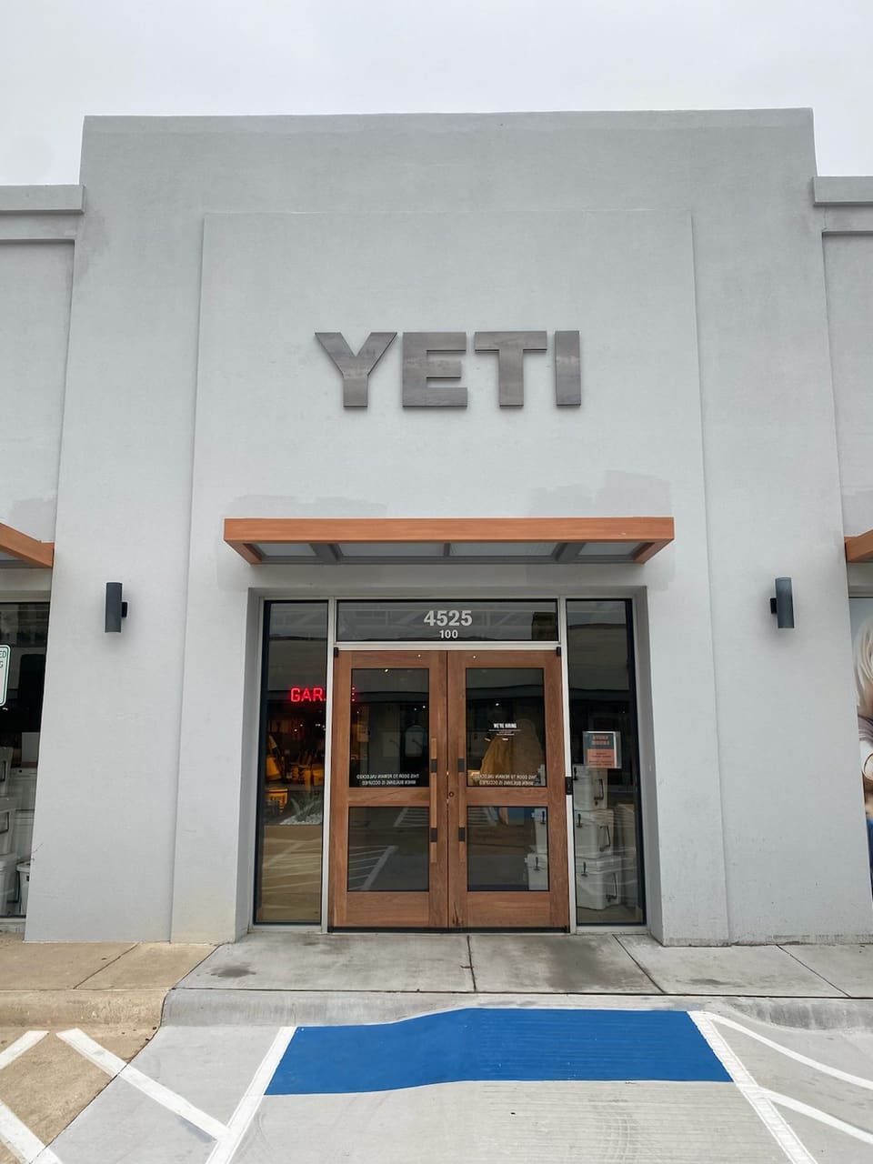 Store entrance with double wood doors beneath a large YETI sign